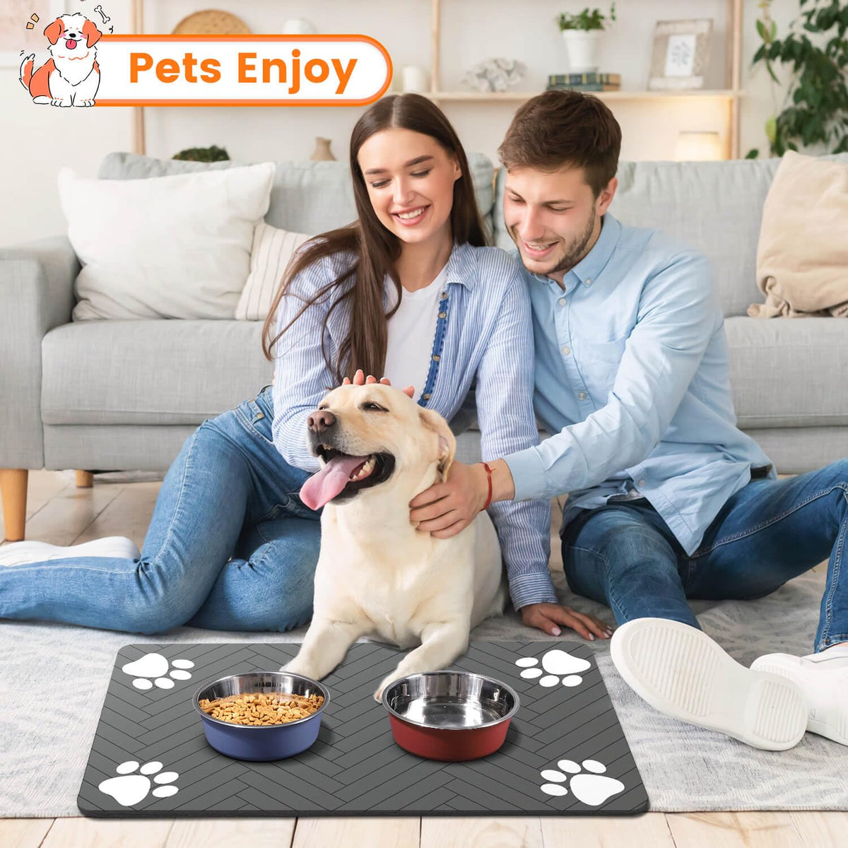 Couple sitting with their Labrador beside the feeding mat, which holds a food bowl and a water bowl