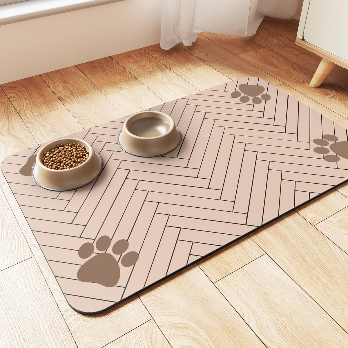 Pink herringbone pet feeding mat with paw-print corners holding a food bowl and water bowl